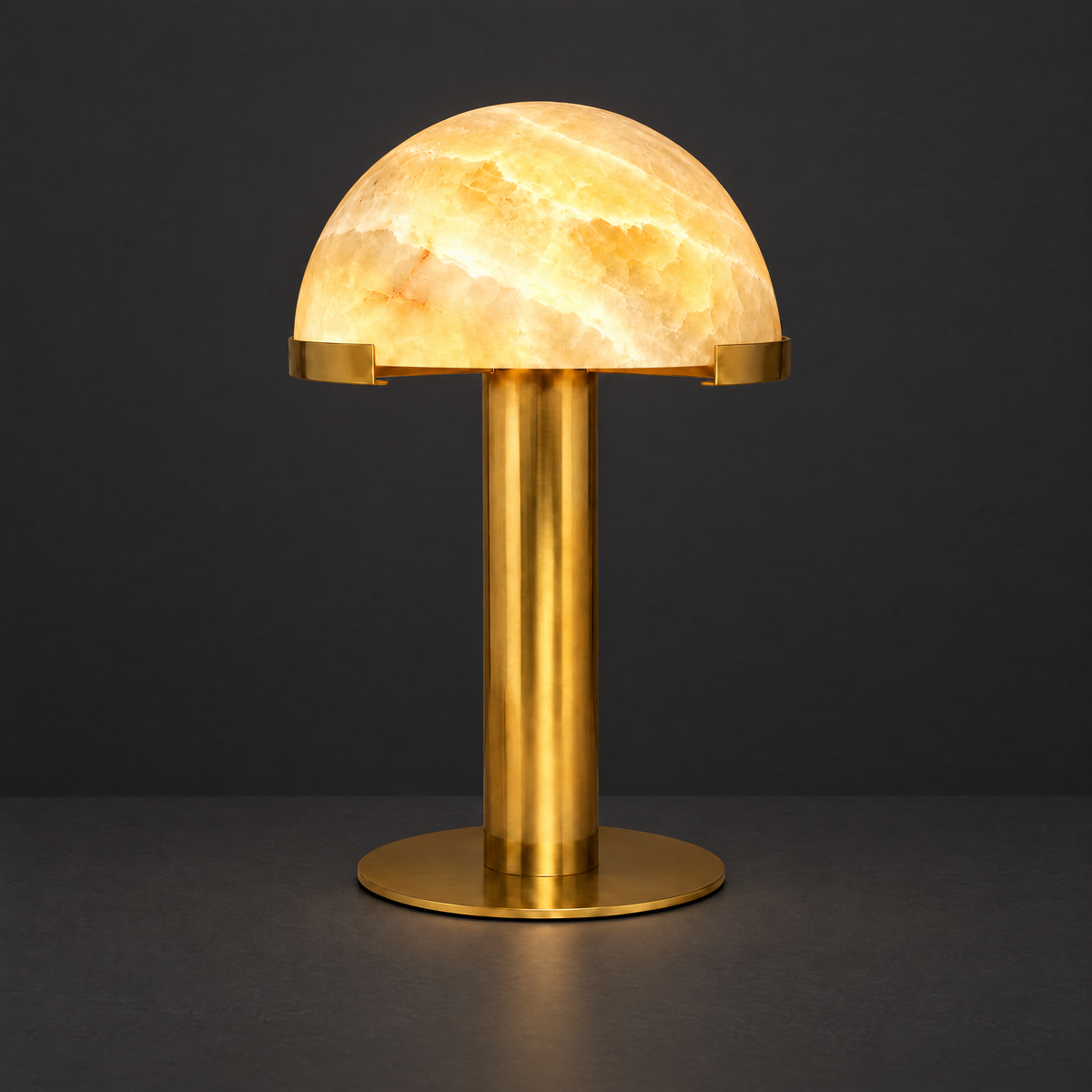Honey Onyx Dome Table Lamp with Brass Stem on a dark charcoal grey studio backdrop