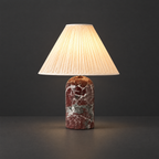 Red Marble Table Lamp with Pleated Shade on a dark charcoal grey studio backdrop