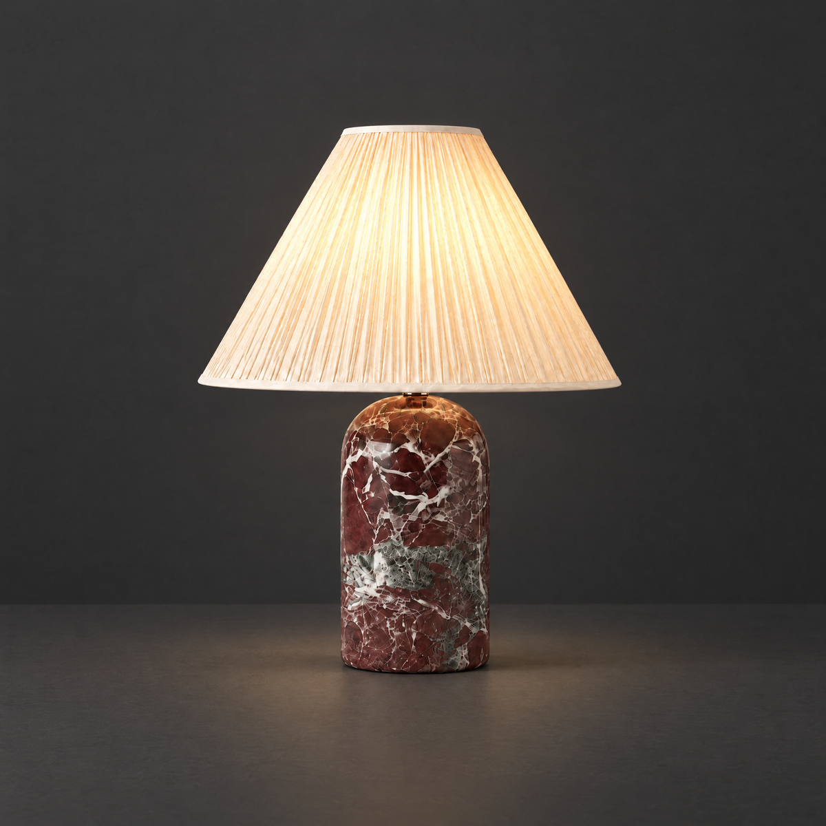 Red Marble Table Lamp with Pleated Shade on a dark charcoal grey studio backdrop