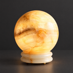 Onyx Globe Table Lamp with Brass Detailing on a dark charcoal grey studio backdrop
